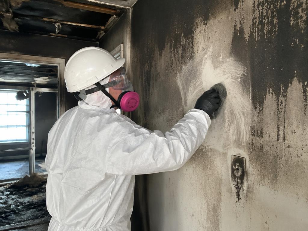 Technician removing soot from walls after a house fire in Colorado Springs